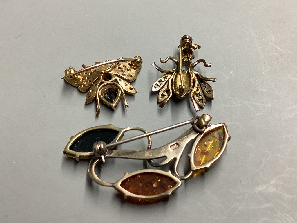 Two diamond and gemstone-set yellow metal insect brooches, largest 25mm, gross 7.8 grams and a silver and amber foliate openwork brooch